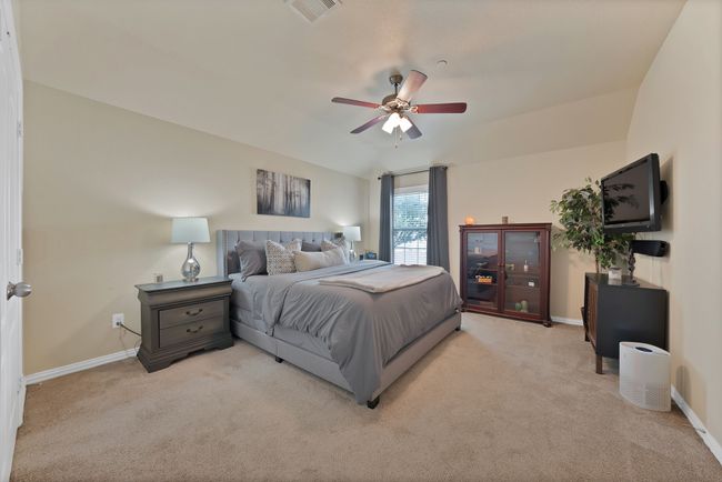 Bedroom featuring light colored carpet, baseboards, ceiling fan, and vaulted ceiling | Image 30