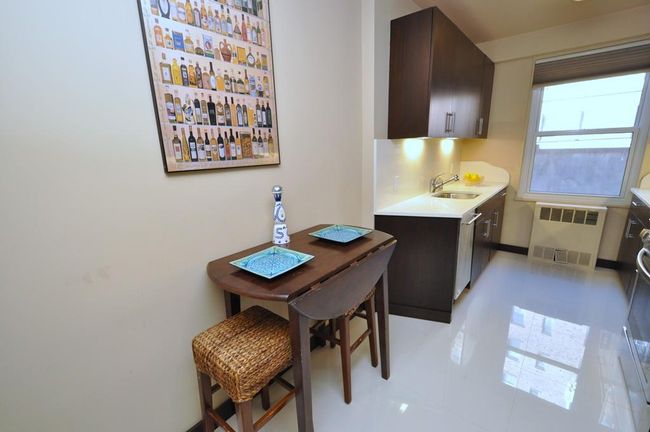 Fully renovated Eat-in-Kitchen has custom mocha colored cabinets, Quarts counters and stainless steel appliances including a wine cooler, dishwasher, microwave, range and refrigerator. | Image 15