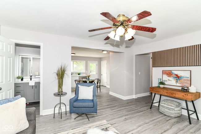 sitting room with wood finished floors, ceiling fan, and baseboards | Image 4