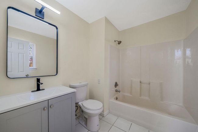 Full bath featuring tile patterned floors, toilet, vanity, and bathing tub / shower combination | Image 22