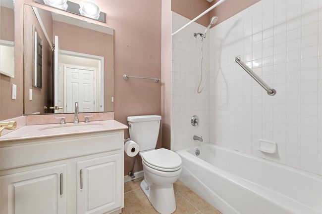 Main floor bath has tub/shower, grab bars, ceramic floors | Image 8