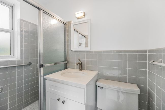 Bathroom with tile walls, a shower stall, and vanity | Image 19