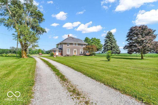 view of side of property featuring driveway, a yard, and a chimney | Image 10