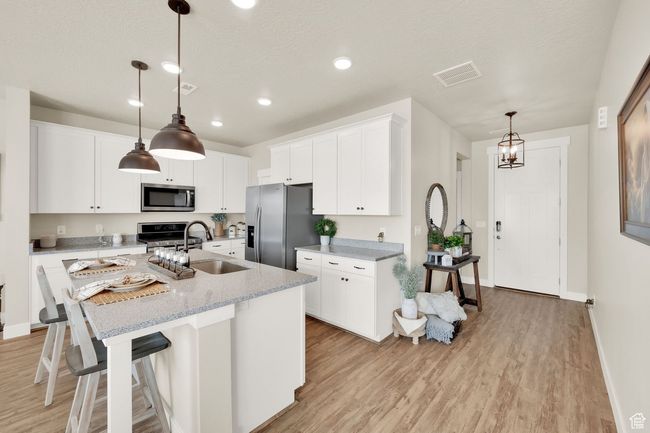 Kitchen with appliances with stainless steel finishes, a sink, light wood-style floors, a center island with sink, and recessed lighting | Image 13