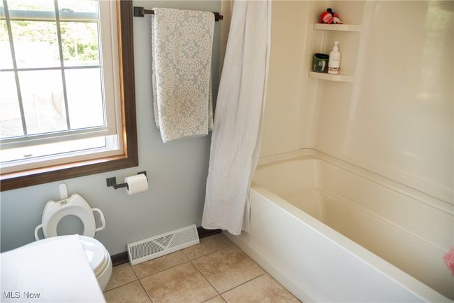 Bathroom featuring tile patterned flooring and shower / bath combo with shower curtain | Image 38