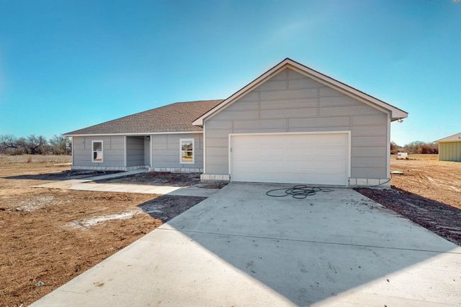 Ranch-style home featuring concrete driveway, a garage, and a shingled roof | Image 6