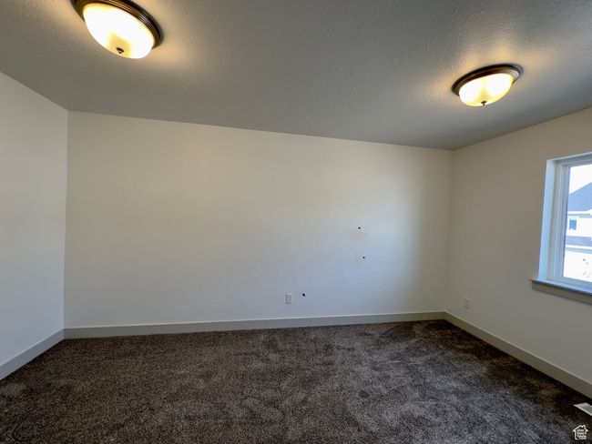 Unfurnished room featuring dark colored carpet | Image 11