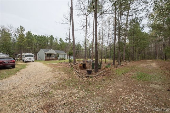 View of front of house with dirt driveway and a view of trees | Image 29