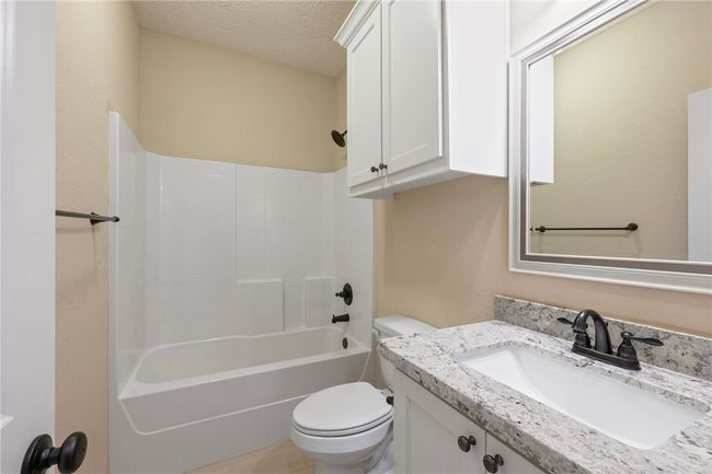 Full bathroom featuring vanity, tub / shower combination, and a textured ceiling | Image 20