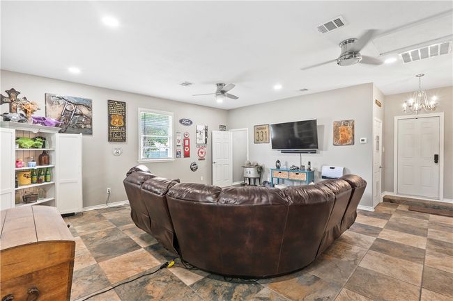 Living area featuring ceiling fan, stone finish flooring, a chandelier, and recessed lighting | Image 26