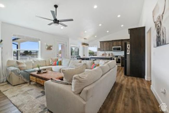 Living area featuring recessed lighting, lofted ceiling, wood finished floors, a ceiling fan, and baseboards | Image 8