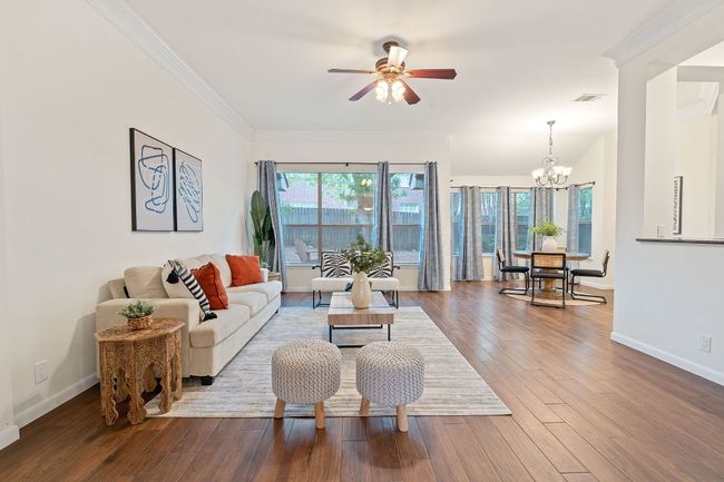 Walls of windows across the back of the home draw in natural light and frame serene backyard views. | Image 9
