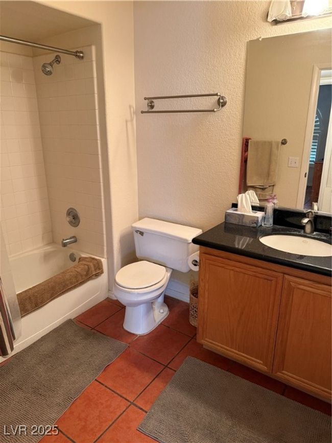 Full bath with bathtub / shower combination, tile patterned floors, toilet, a textured wall, and vanity | Image 14
