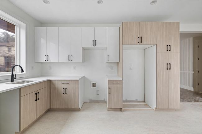 Kitchen featuring light countertops, light brown cabinetry, and a sink | Image 19