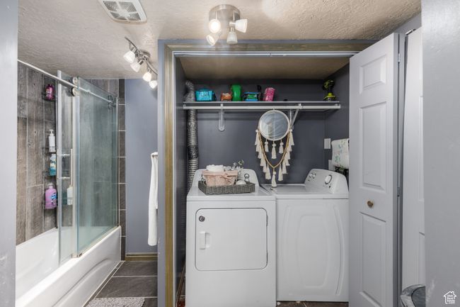 Washroom featuring independent washer and dryer, a textured ceiling, and tile patterned flooring with a full bath | Image 18