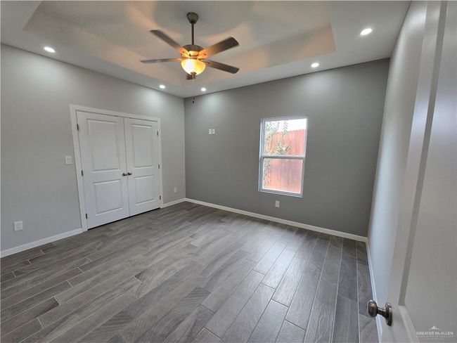 Unfurnished bedroom with dark wood-type flooring, recessed lighting, baseboards, and ceiling fan | Image 19