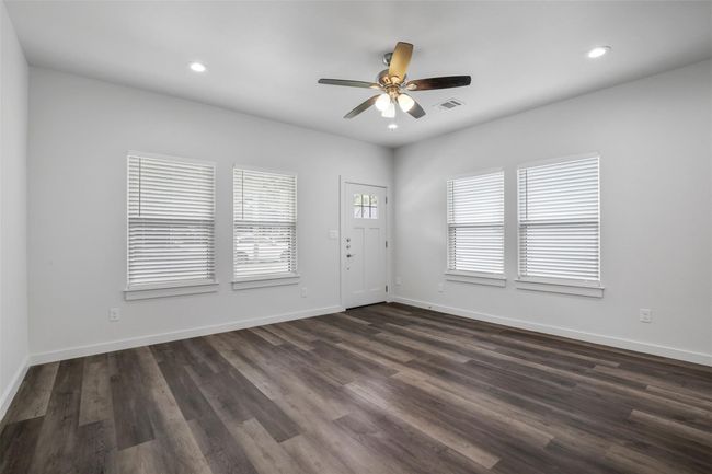 Unfurnished room with ceiling fan, dark wood-style flooring, and recessed lighting | Image 5
