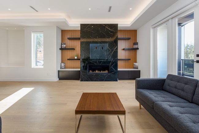 Living room featuring visible vents, wood walls, recessed lighting, a fireplace, and light wood-style floors | Image 13