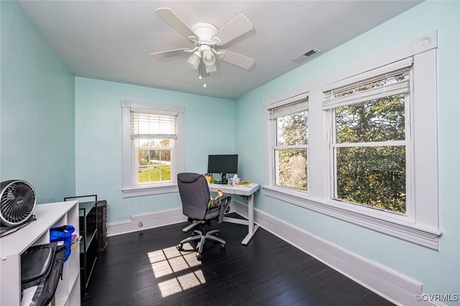Bedroom with baseboards, dark wood-style floors, and visible vents | Image 18