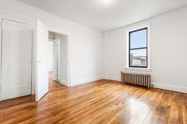 Spare room with radiator, light wood finished floors, and baseboards | Image 7