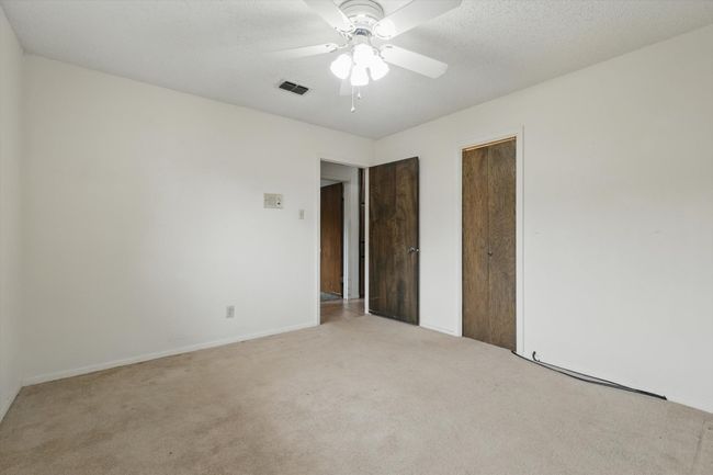 Unfurnished bedroom featuring carpet flooring, baseboards, a ceiling fan, and a closet | Image 28