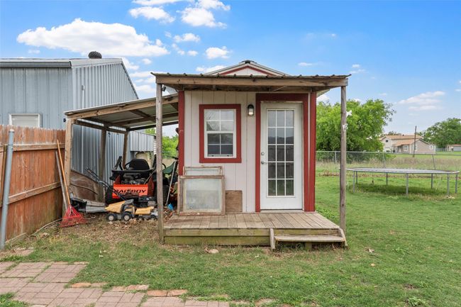 View of outdoor structure featuring a trampoline, an outdoor structure, and fence | Image 24