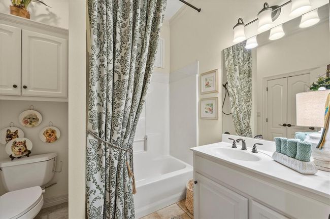 Full bathroom with tile floors, toilet, shower / bath combo with shower curtain, and large vanity | Image 25