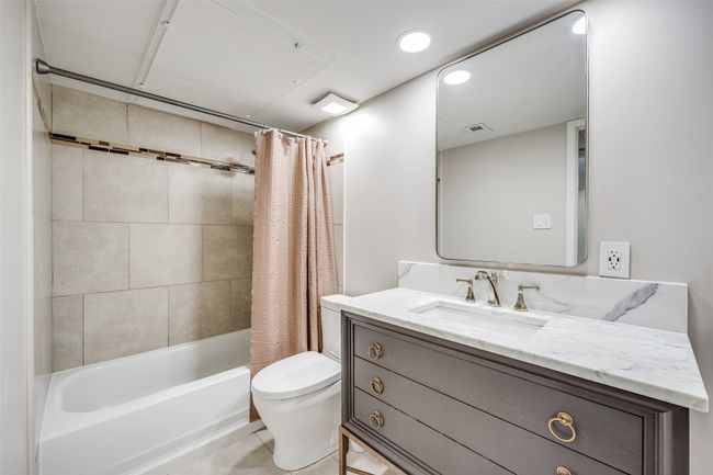 Washroom featuring stacked washing machine and dryer and dark wood finished floors | Image 9