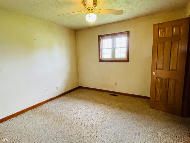 spare room with carpet floors, ceiling fan, a textured ceiling, and baseboards | Image 18