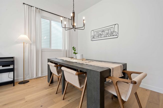 Dining area with a notable chandelier, baseboards, and light wood finished floors | Image 5