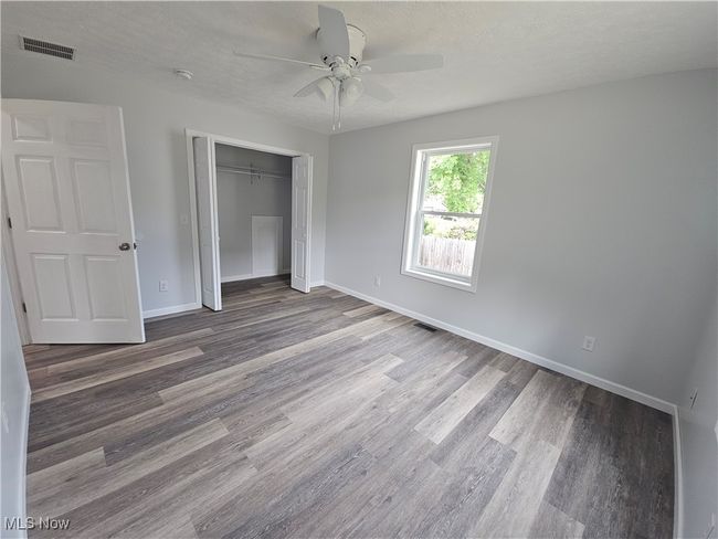 Bedroom 2 with large closet showing access to bathtub for easy plumbing, and ceiling fan | Image 19