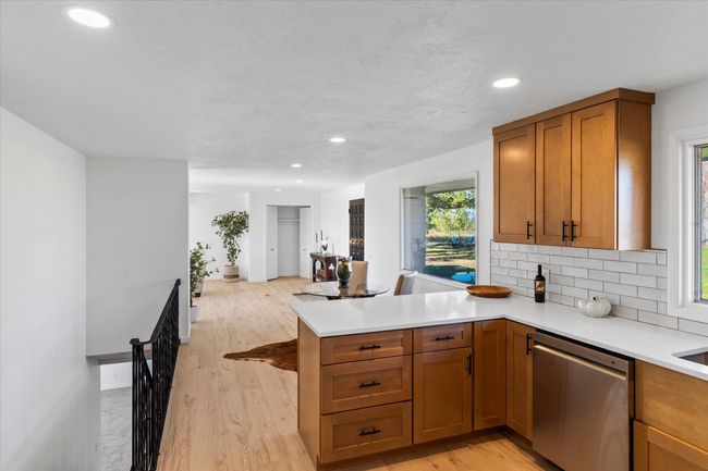 Kitchen featuring dishwasher, light hardwood / wood-style flooring, kitchen peninsula, and a wealth of natural light | Image 18