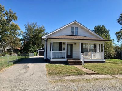 Bungalow-style home featuring a garage, a front lawn, and a porch | Image 1