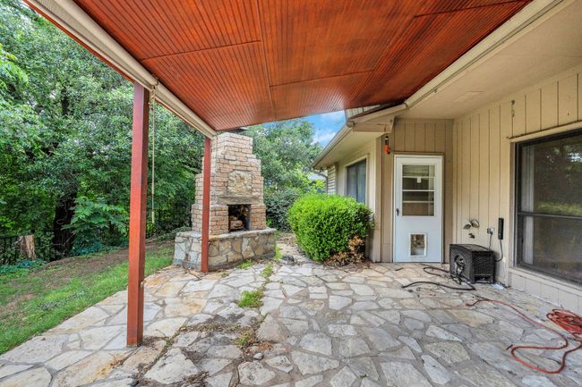 View of patio / terrace with an outdoor stone fireplace and central AC | Image 5