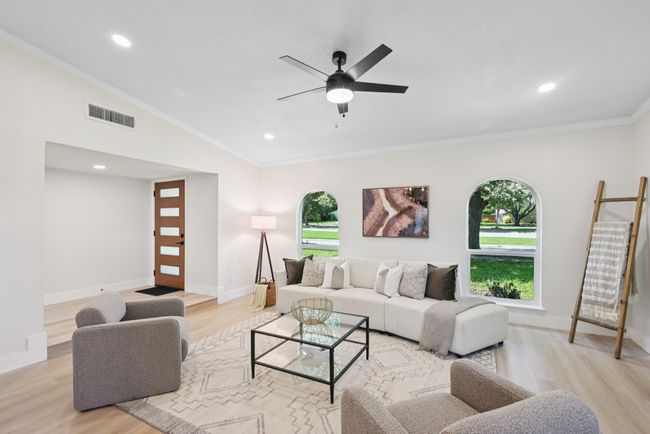 Living room featuring light wood finished floors, plenty of natural light, ceiling fan, crown molding, and recessed lighting | Image 10