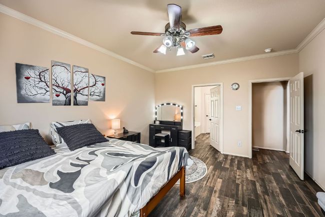 Bedroom with ornamental molding, wood finished floors, and a ceiling fan | Image 19