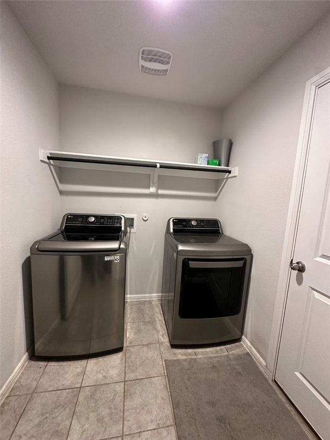 Laundry room featuring baseboards, visible vents, washer and clothes dryer, and laundry area | Image 24