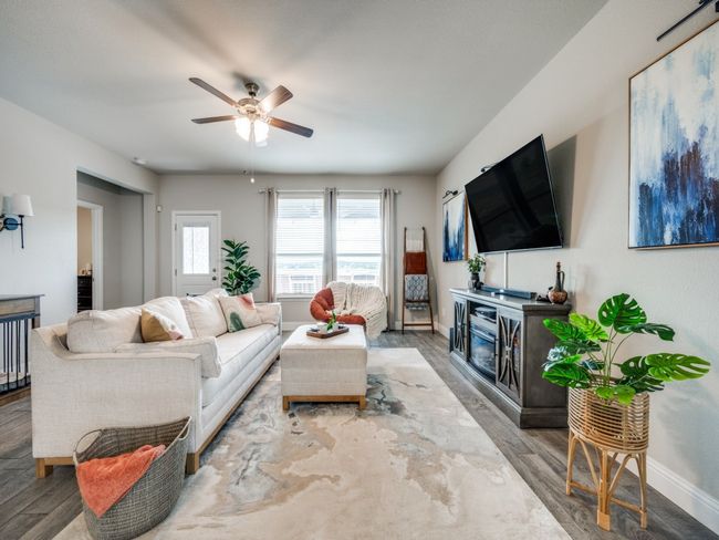 Wood-look tile flooring adds warmth and style, while large windows fill the space with natural light. | Image 5