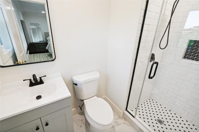 Bathroom with a shower stall, vanity, and marble finish flooring | Image 23