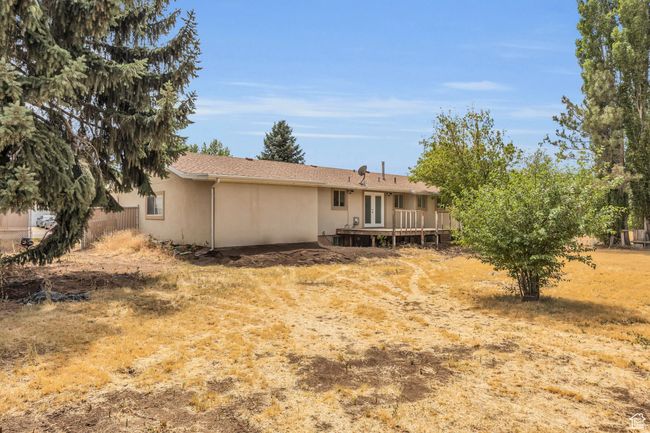 Back of house featuring stucco siding, a wooden deck, and french doors | Image 34