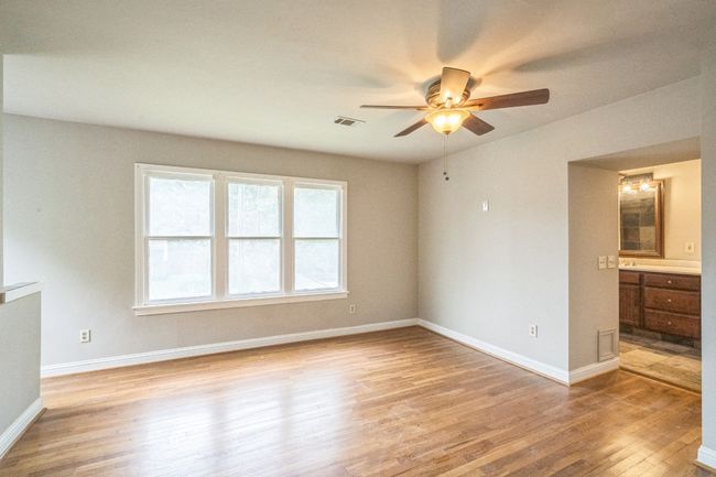 Spare room featuring light wood-style flooring and a ceiling fan | Image 12