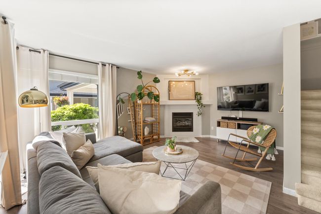 Living area with baseboards, wood finished floors, and a glass covered fireplace | Image 8