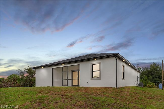 Back house at dusk with central AC and a yard | Image 7