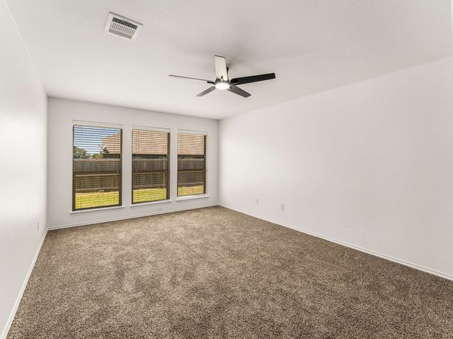 Carpeted spare room featuring ceiling fan and baseboards | Image 18