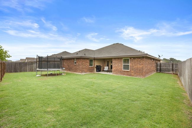 Back of property featuring a trampoline, brick siding, and a fenced backyard | Image 27