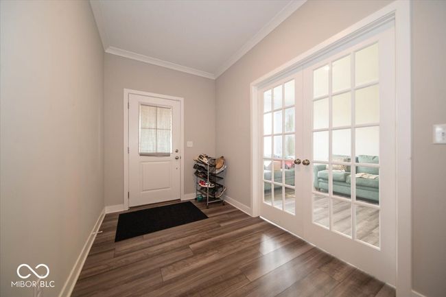 doorway featuring crown molding, dark wood-style floors, and french doors | Image 5