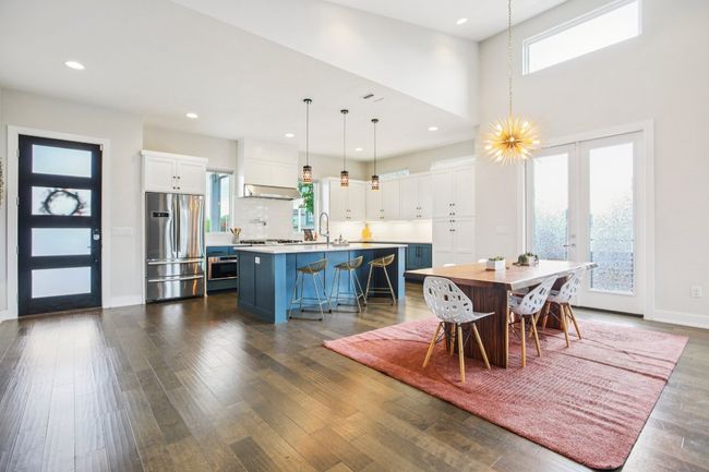 Dining area featuring dark wood-style flooring, a towering ceiling, and recessed lighting | Image 16