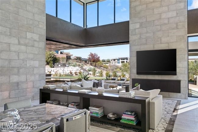 Living room featuring a high ceiling and a fireplace | Image 14