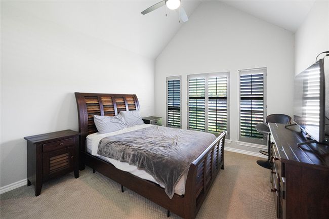 Bedroom featuring multiple windows, carpet floors, baseboards, and high vaulted ceiling | Image 18