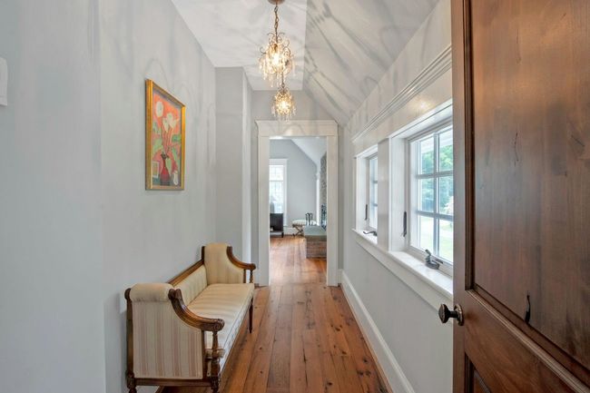 Corridor featuring a chandelier, vaulted ceiling, light wood-type flooring, and baseboards | Image 18